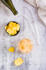 Beer slush in a glass and chips in a bowl on the table. Trendy summer drink. Top and vertical view