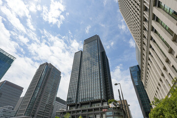 Fototapeta premium 丸の内、壁、空、塔、灰色、背景、外観、建設、遠近法、オフィス、現代、高層ビル、形状、技術、シーン、コーナー、広場、日本、東京、建築、建物、都市、構造、デザイン、都市、窓、企業、青、工業、スクレイパー、ビジネス、働く、通り、トップ、スカイライン、建築家、鏡、鉄、誰も、見上げ、鮮やか、開発、都心、豪華、現代、コンクリート、高い、眺め、都市風景、高い。 