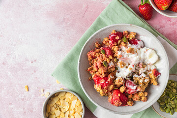 Delicious strawberry crumble with ice cream, almonds and pumpkin seeds in a plate on pink background. Top view