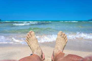 Sandige Füße an einem wunderschönen türkisblauen Strand