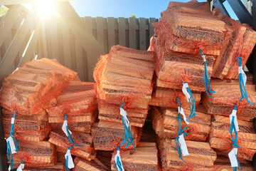 Firewood in the grid. Big pile of firewood packed in nets for sale