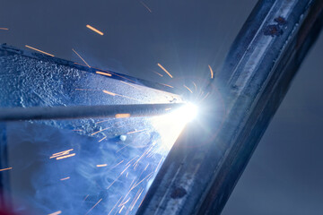 The moment of welding with an electrode, a lot of sparks and smoke, welding work