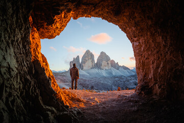 Tre Cime Di Lavaredo culmine dans une incroyable lumière orange au coucher du soleil. Vue depuis la grotte en montagne contre trois pics de Lavaredo, Alpes Dolomites, Italie, Europe. Photographie de paysage