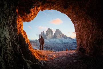 Fotobehang Dolomieten Tre Cime Di Lavaredo piekt in ongelooflijk oranje zonsonderganglicht. Uitzicht vanaf de grot in de bergen tegen de drie toppen van Lavaredo, Dolomieten, Italië, Europa. Landschapsfotografie