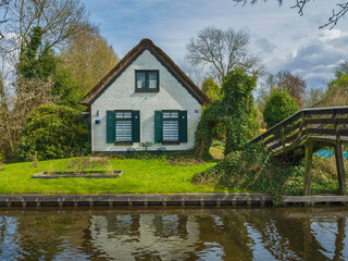 A white old house on the canal waterfront in Giethoorn village, Netherlands