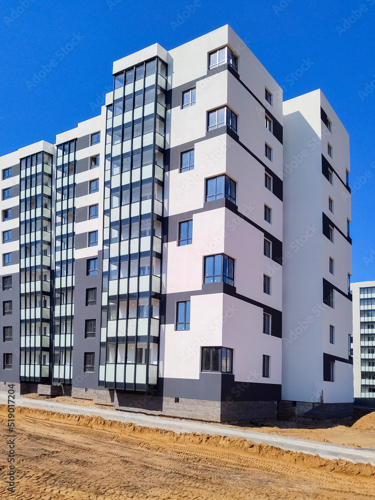 Wall mural new modern apartment building against blue sky.