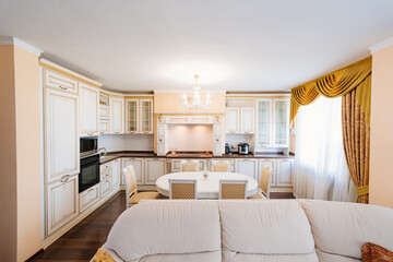 The interior of a large and spacious kitchen-living room in a classic style. 