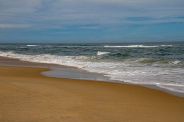 Fototapeta na wymiar waves crashing into the beach in the morning in the Outer Banks, North Carolina