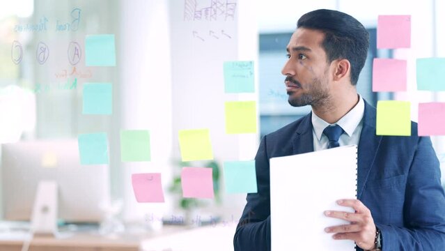 Marketing agent thinking of global business branding ideas and creative solutions on visual aid board inside an office. Smiling, confident and ambitious manager, ceo or boss planning success strategy