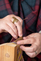 Obraz premium An ancient Roman woman makes yarn and sews from vintage wool. Reconstruction of the events of the Roman Empire