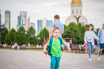 Portrait of a child, a boy against the backdrop of urban landscapes of skyscrapers and high-rise buildings in the open air. Children, Travel. Lifestyle in the city. Center, streets.