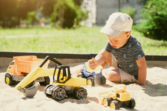 Child playing in sandbox. Little boy having fun on playground in sandpit. Outdoor creative activities for kids. Summer and childhood concept