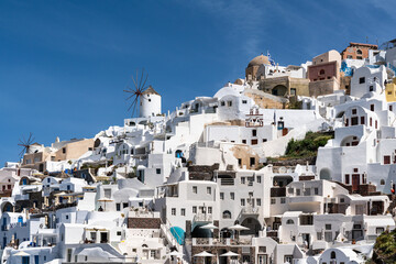 Fototapeta na wymiar Scenic view of Oia with its typical windmill and white house. Oia is a top destination for honeymoon and romantica vacations, Santorini, Greece