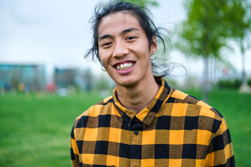 Portrait of young man with plaid shirt and Asian features lifestyle and outdoors