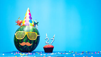 Creative happy birthday greeting with muffin festive garlands decoration. Fan greeting card. Copy space. Beautiful happy birthday background with burning candles with number 27