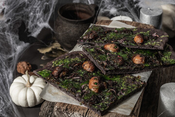 Obraz na płótnie Canvas Halloween concept food. Flatbread or pizza with squid Ink, green cheese, mushrooms and purple onion