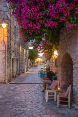 Beautiful decorated streets of Areopoli town with colorful flowers around the traditional stoned buildings in Laconia, Greece