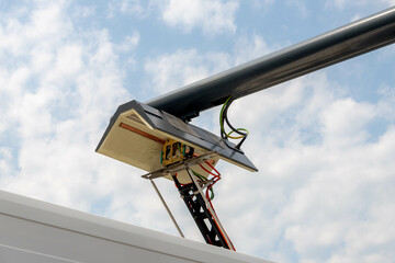Pantograph of a city bus connecting on electric line with blue sky as background, Electric and...
