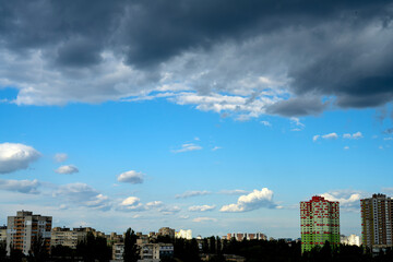 Sunny blue sky with clouds over the city. Clouds move smoothly over the city