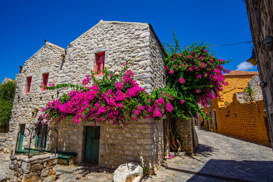 Beautiful decorated streets of Areopoli town with colorful flowers around the traditional stoned buildings in Laconia, Greece