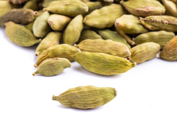 Green cardamom pods on white background.