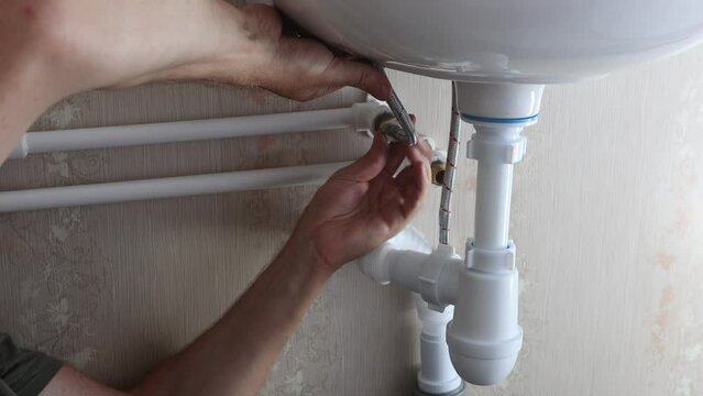 Connecting faucet to bathroom sink during plumbing repairs and installations.