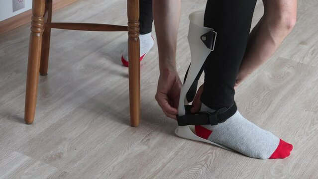 Foot drop support brace, ankle-foot orthosis is attached to injured leg.
