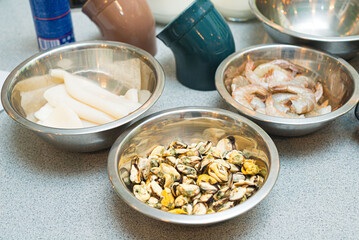 Seafood in metal bowls. Raw foods. Mussels, shrimp and squid.