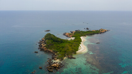 Island with a sandy beach and azure water surrounded by a coral reef. Pigeon Island, Sri Lanka.