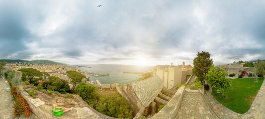Aerial view of a tourist woman sitting in a terrace on harbor of Bastia city, in Corsica island of...