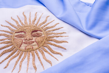 Argentine National flag with embroidered sun in gold threads selective focus.