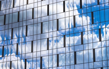 Reflection in the building blue sky with light clouds