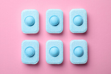 Water softener tablets on pink background, flat lay