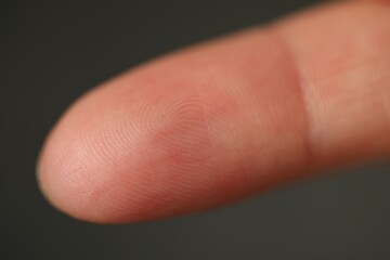 Closeup view of human finger on dark background
