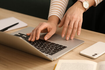 Woman with modern laptop learning at table indoors, closeup