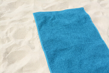 Fototapeta premium Beautiful soft blue towel on sandy beach