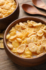 Tasty cornflakes with milk served on wooden table, closeup