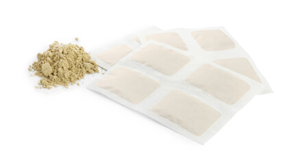 Mustard powder and plasters on white background