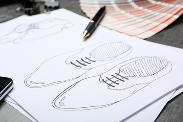Drawing of shoes on table, closeup. Designer's workplace