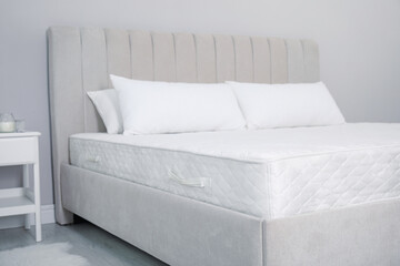 Comfortable bed with soft white mattress and pillows indoors