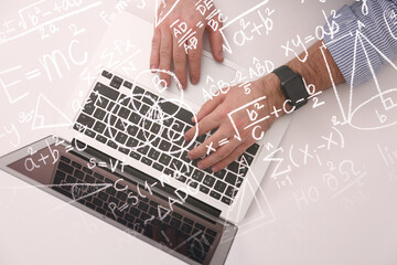 Science and education concept. Illustration of basic physics and mathematics formulas and man working on laptop at table, top view - obrazy, fototapety, plakaty