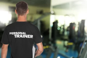 Foto auf Leinwand Professional personal trainer with clipboard in gym. Space for text © New Africa