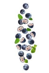 Tasty ripe blueberries with green leaves flying on white background