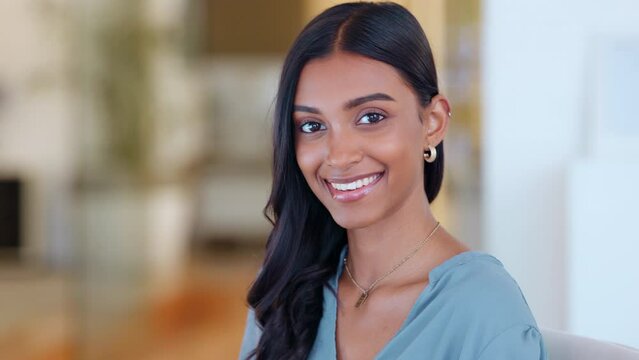 Face of a happy businesswoman in a corporate office. Portrait of a young confident Indian entrepreneur or trendy marketing designer smiling while standing indoors in a bright modern corporate office