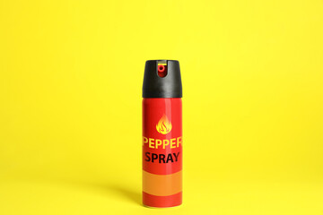 Bottle of gas pepper spray on yellow background