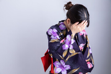 ゆかたを着て頭を抱える女性　Japan