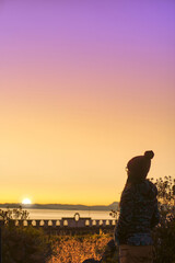 Woman enjoying the sunrise with a view from the alto Sancayuni stadium of the Amantaní island, Titicaca lake
