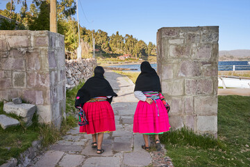 Indigenous women (Cholita) walking to the Titicaca lake