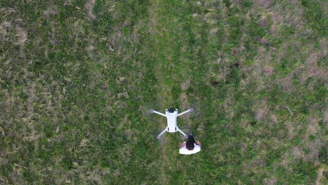 Top Down Aerial View, Quadcopter Drone Hovering Above Young Man Doing Somersault Roll Flip on Green Field, High Angle