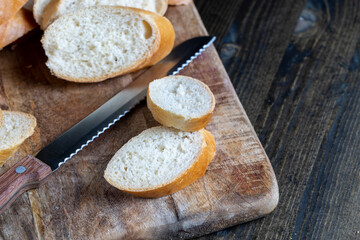 Fototapeta na wymiar wheat baguette cut into pieces on a cutting board